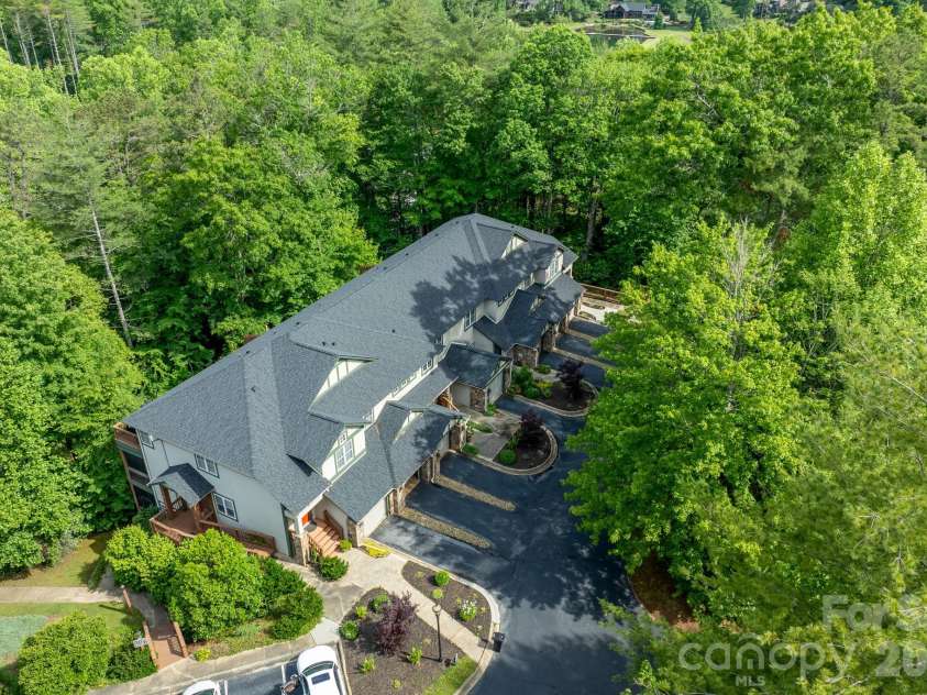 99 Ridgetop Circle, Brevard, NC 28712.  MLS# CAR4387560, YatesRealty ID 28540. Beautifully Maintained Community Setting – Aerial perspective highlighting the attractive architecture, landscaped grounds, and peaceful wooded surroundings.