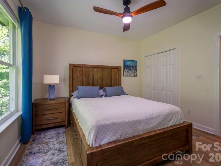 99 Ridgetop Circle, Brevard, NC 28712.  MLS# CAR4387560, YatesRealty ID 28540. Bright & Inviting Guest Bedroom – Well-appointed guest bedroom with oversized windows, tranquil wooded views, and ample space for guests or flexible use as a den or office.