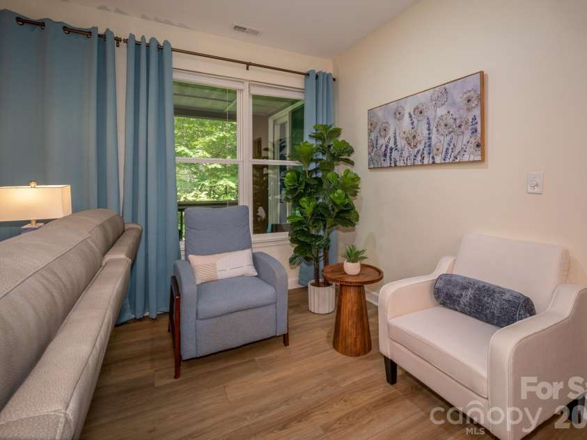 99 Ridgetop Circle, Brevard, NC 28712.  MLS# CAR4387560, YatesRealty ID 28540. Flexible Dining or Sitting Area with Porch Access – Versatile space ideal for a dining area, featuring large windows, abundant natural light, and seamless access to the screened porch with peaceful wooded views beyond.