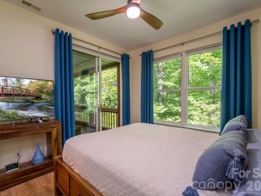 99 Ridgetop Circle, Brevard, NC 28712.  MLS# CAR4387560, YatesRealty ID 28540. Guest Bedroom with Private Screened Porch Access – Comfortable secondary bedroom offering sliding door access to the screened porch, abundant natural light, and a relaxing connection to nature.