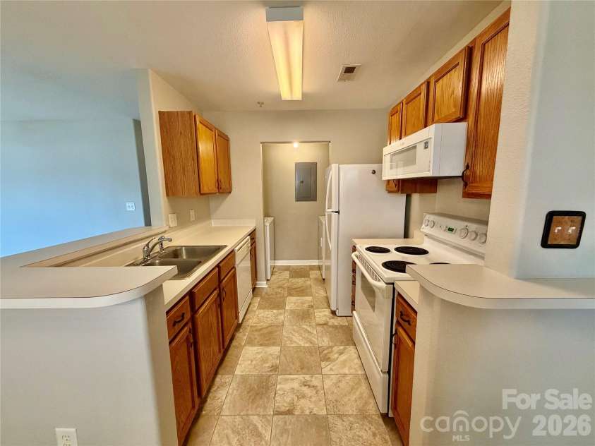 4002 Town Center Road, Harrisburg, NC 28075.  MLS# CAR4381248, YatesRealty ID 28554. View of Kitchen. Laundry is beyond kitchen in laundry closet. Additional space for storage above laundry.