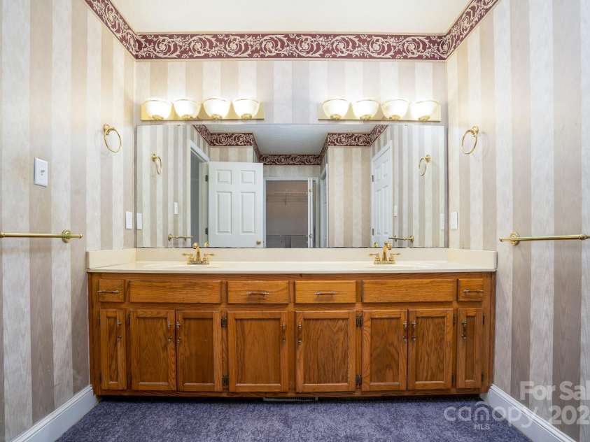 151 Oak Point Drive, Cherryville, NC 28021.  MLS# CAR4135718, YatesRealty ID 2860. Primary bathroom vanity. Linen closet and large closet in the mirror's reflection.