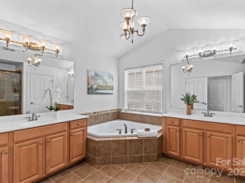 110 Preserve Way, Mooresville, NC 28117.  MLS# CAR4250582, YatesRealty ID 28619. Primary bathroom with dual vanities, jetted tub, tiled shower, and water closet.