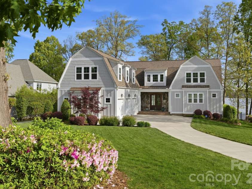 20727 Pointe Regatta Drive, Cornelius, NC 28031.  MLS# CAR4370865, YatesRealty ID 28632. Charming waterfront home with manicured landscaping, inviting front entry, and a spacious three-car garage.