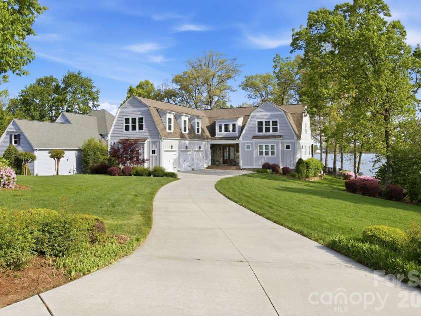 20727 Pointe Regatta Drive, Cornelius, NC 28031.  MLS# CAR4370865, YatesRealty ID 28632. Front exterior showcases a well-maintained lawn, landscaped yard, and inviting covered entry.