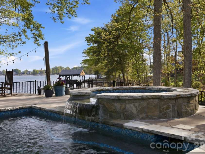 20727 Pointe Regatta Drive, Cornelius, NC 28031.  MLS# CAR4370865, YatesRealty ID 28632. In-ground pool and spa with waterfall feature overlook a spacious patio and scenic water views.