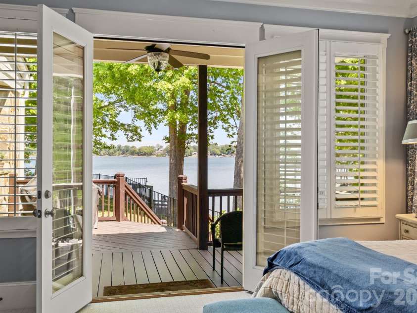 20727 Pointe Regatta Drive, Cornelius, NC 28031.  MLS# CAR4370865, YatesRealty ID 28632. Primary suite features expansive windows and French doors that open to a covered deck by the pool.