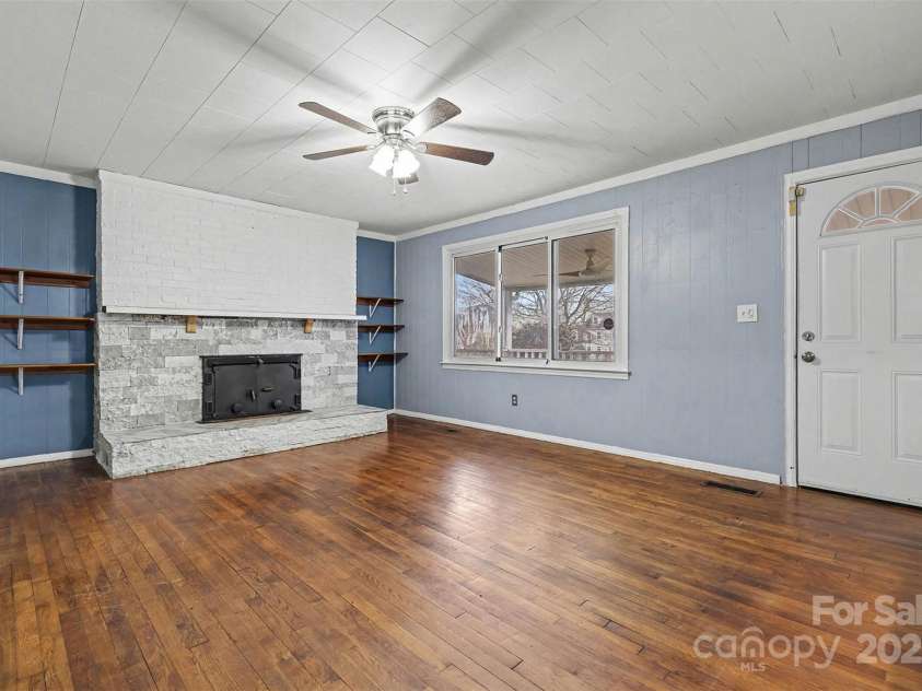 119 Moore Drive, Gastonia, NC 28056.  MLS# CAR4332115, YatesRealty ID 2865. Inviting living area featuring a striking stone fireplace that serves as a warm and charming focal point. The fireplace is complemented by built-in shelving on either side, perfect for displaying décor or storing books.