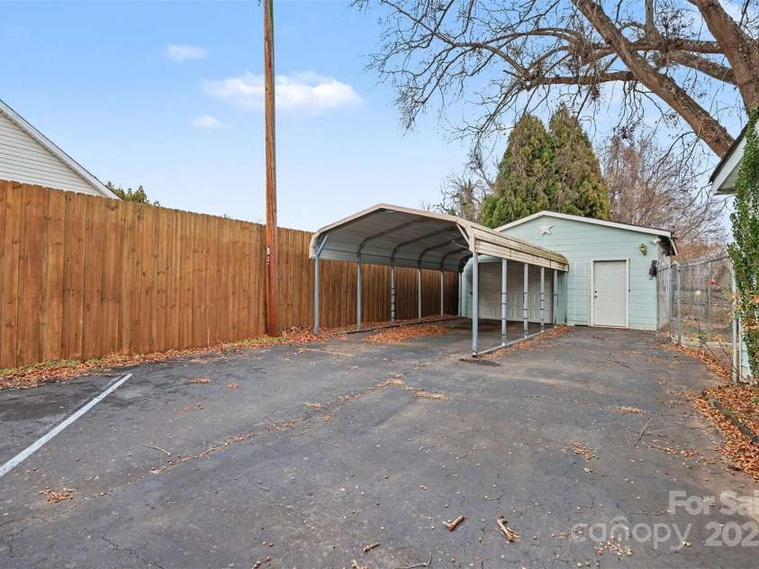 119 Moore Drive, Gastonia, NC 28056.  MLS# CAR4332115, YatesRealty ID 2865. Large paved driveway providing ample off-street parking, complemented by a covered carport and detached garage for added convenience. The extended parking area offers plenty of space for multiple vehicles, guests, or recreat