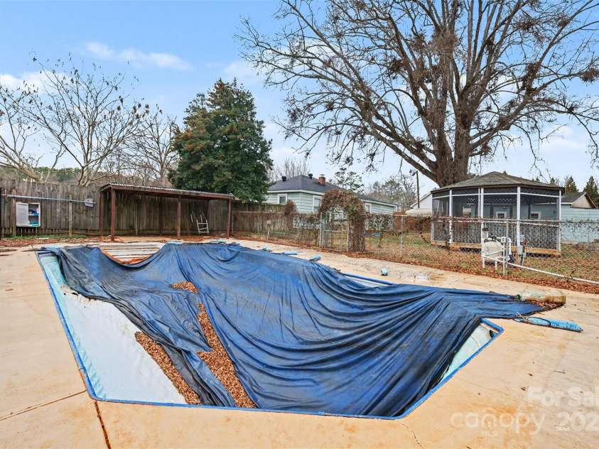 119 Moore Drive, Gastonia, NC 28056.  MLS# CAR4332115, YatesRealty ID 2865. Non-operational in-ground swimming pool with surrounding concrete deck, offering a dedicated outdoor recreation space. The fenced pool area provides privacy and room for future updates or customization, allowing buyers to ta
