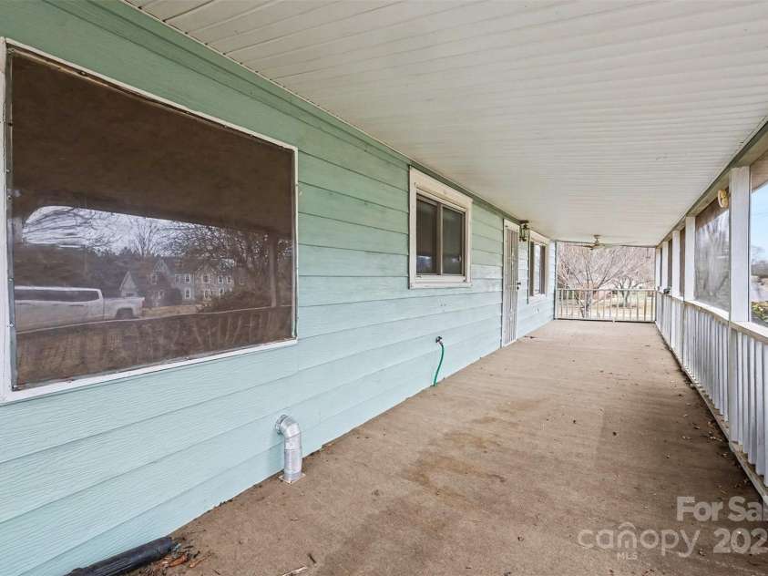 119 Moore Drive, Gastonia, NC 28056.  MLS# CAR4332115, YatesRealty ID 2865. Spacious screened-in front porch extending the length of the home, offering a comfortable outdoor living area perfect for relaxing or entertaining. The covered design provides shade and protection from the elements, while th