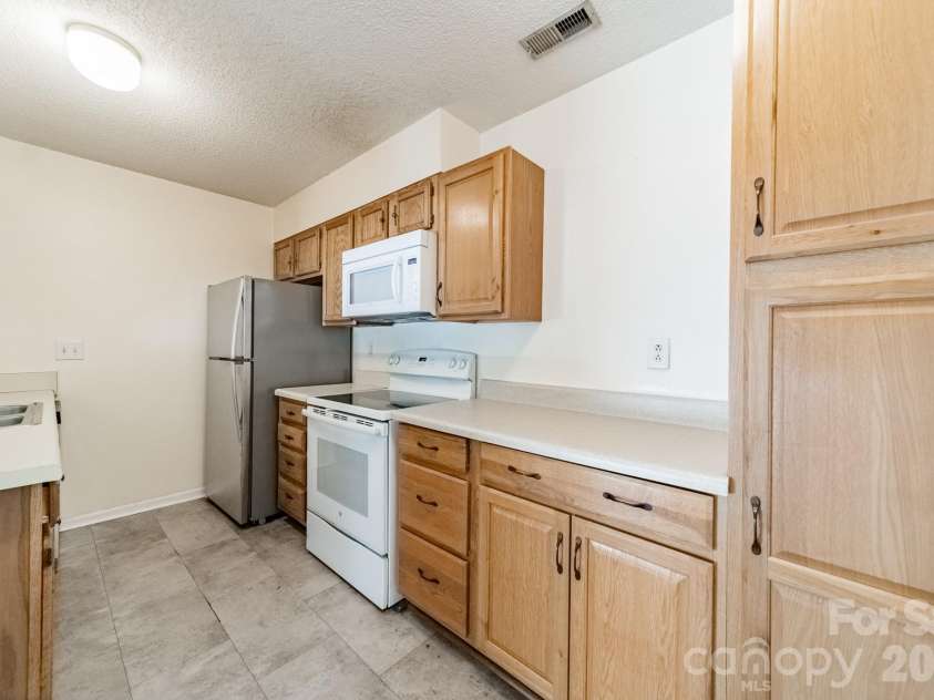 9605 Vinca Circle, Charlotte, NC 28213.  MLS# CAR4385047, YatesRealty ID 28719. Kitchen with white range and ample cabinetry