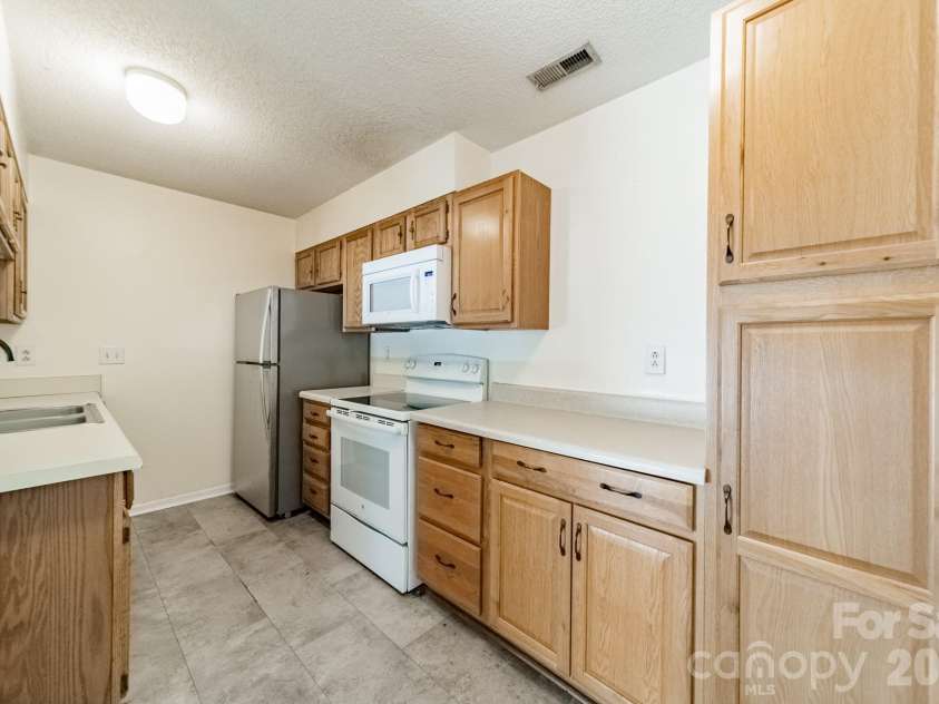 9605 Vinca Circle, Charlotte, NC 28213.  MLS# CAR4385047, YatesRealty ID 28719. Kitchen with wood cabinetry and vaulted ceiling