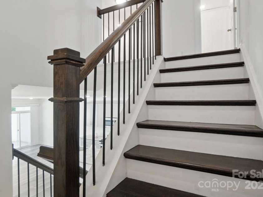 8018 Saluda Drive, Charlotte, NC 28269.  MLS# CAR4255269, YatesRealty ID 28789. Elegant oak tread stairs with modern metal balusters