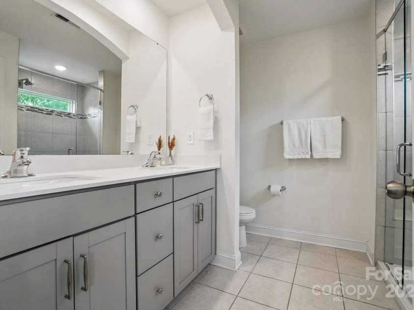 8018 Saluda Drive, Charlotte, NC 28269.  MLS# CAR4255269, YatesRealty ID 28789. Start your day right in this luxe bath with dual sinks and a tiled shower with built-in seat