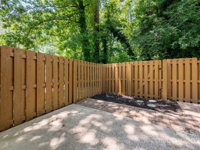 6013 Heath Valley Road, Charlotte, NC 28210.  MLS# CAR4276704, YatesRealty ID 28858. Shaded, tree lined patio with a freshly painted privacy fence!
