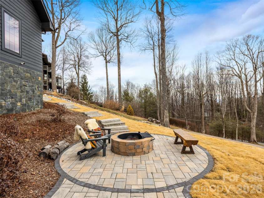 241 Tower Circle, Hendersonville, NC 28739.  MLS# CAR4346762, YatesRealty ID 2892. Circular fire pit area with built-in seating and wooded backdrop