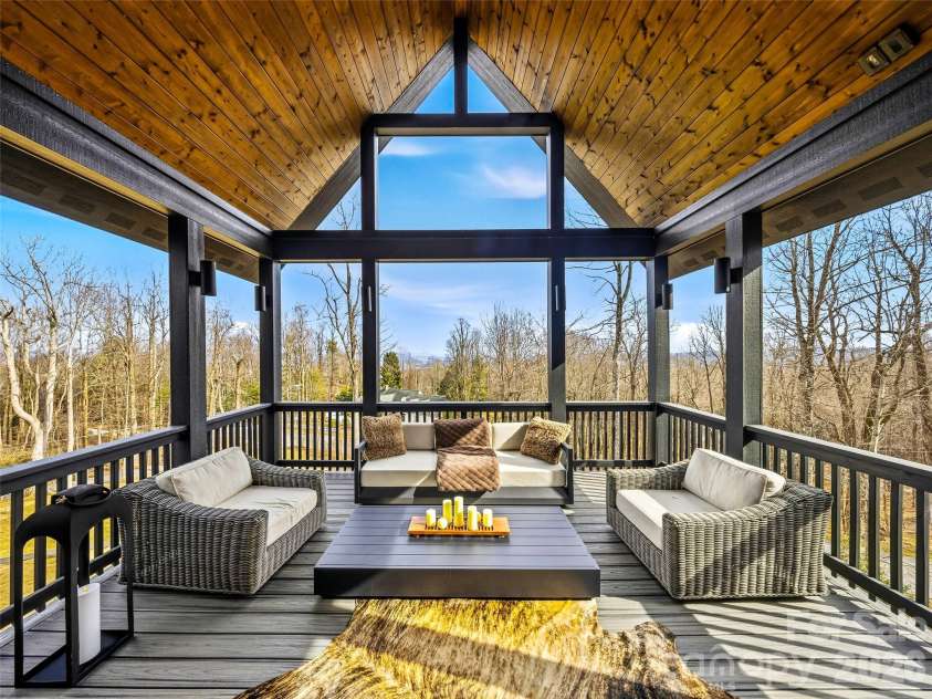 241 Tower Circle, Laurel Park, NC 28739.  MLS# CAR4346762, YatesRealty ID 2892. Covered deck with vaulted wood ceiling and expansive windows capturing serene views