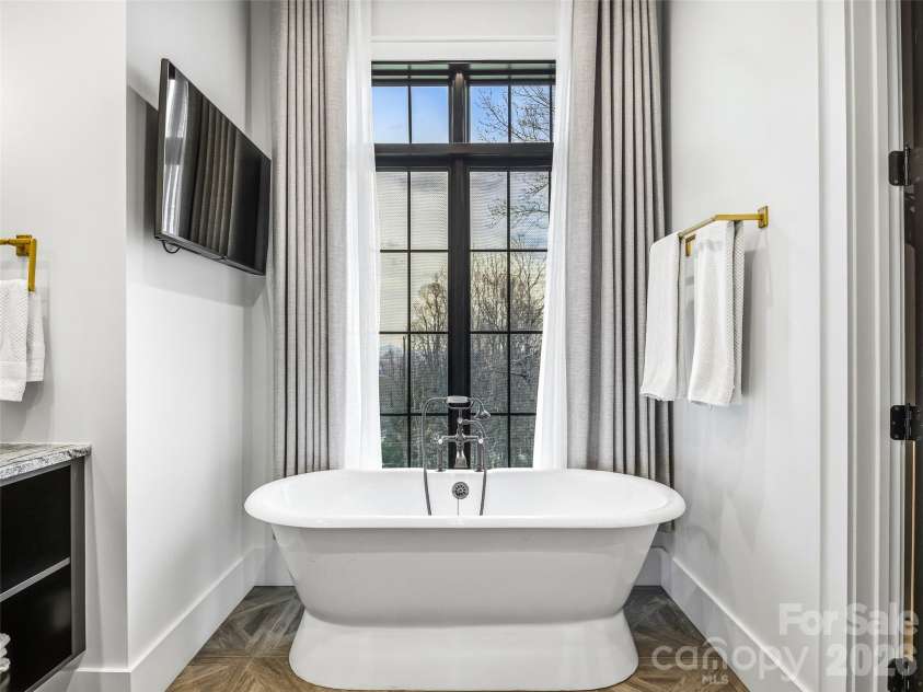 241 Tower Circle, Laurel Park, NC 28739.  MLS# CAR4346762, YatesRealty ID 2892. Freestanding soaking tub positioned beneath large windows for a bright, spa-like retreat
