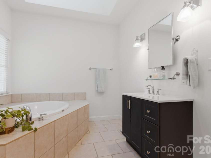 2925 Arbor Knoll, Concord, NC 28025.  MLS# CAR4380633, YatesRealty ID 28948. Large soaking tub underneath skylight in primary bath