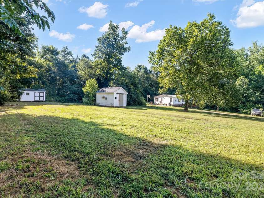 7050 Woodleaf Road, Woodleaf, NC 27054.  MLS# CAR4276614, YatesRealty ID 29035. Backyard to Sheds