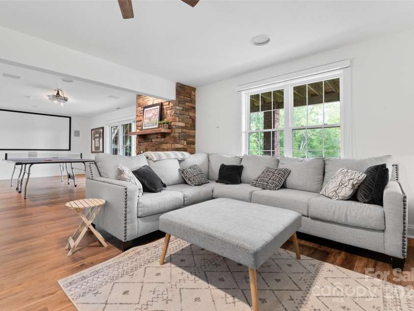 230 Fairway Falls Road, Mills River, NC 28759.  MLS# CAR4256641, YatesRealty ID 29061. Elegant basement family game room with gas fireplace, combining comfort and entertainment.