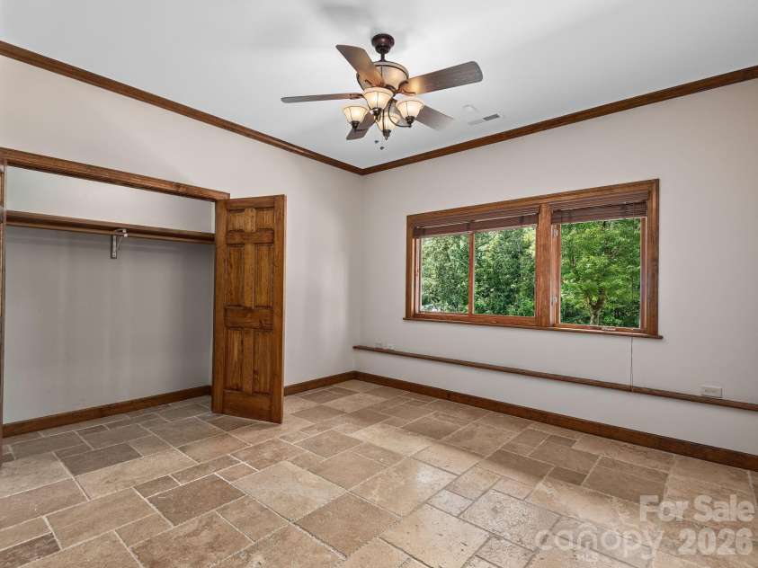 248 Wisdom Cove Road, Flat Rock, NC 28731.  MLS# CAR4413753, YatesRealty ID 29067. Additional sleeping room in walk out basement. This tile remains under the golf carpet throughout basement rooms.