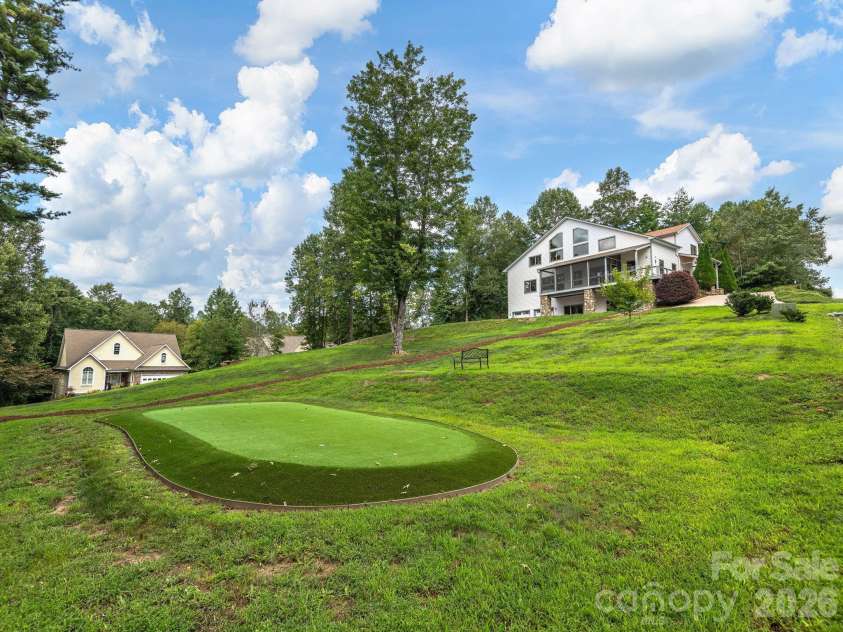 248 Wisdom Cove Road, Flat Rock, NC 28731.  MLS# CAR4413753, YatesRealty ID 29067. View from installed putting green towards the home.