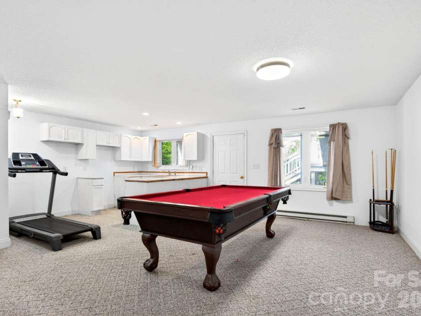 43 Charles Marlowe Drive, Fairview, NC 28730.  MLS# CAR4385183, YatesRealty ID 29070. Large rec room or lower living room. Pool table conveys, lower level kitchen possibilities, entrance door straight ahead.