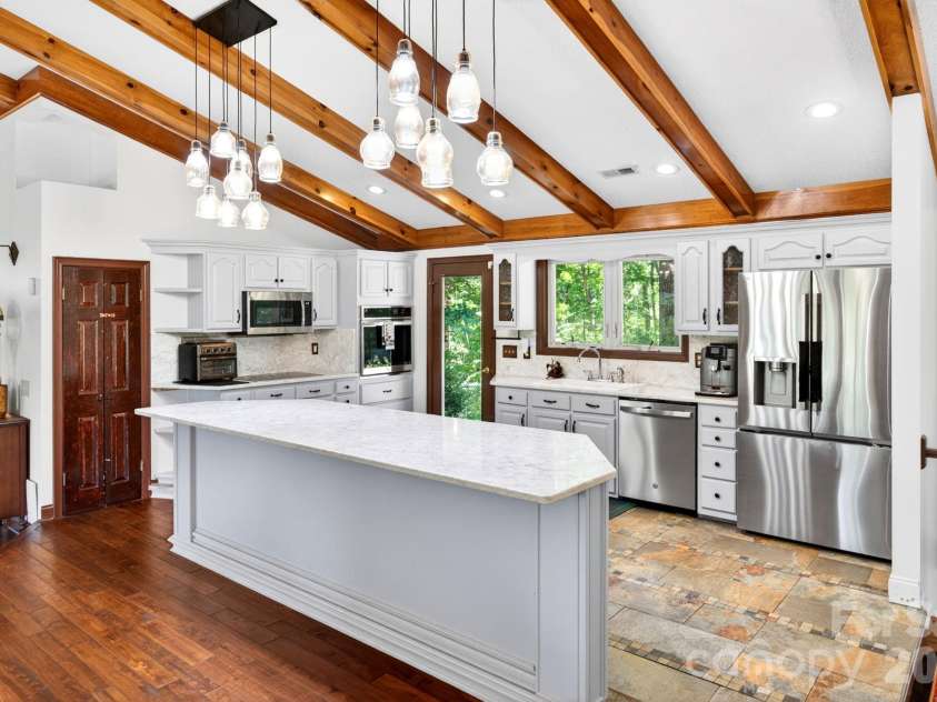 43 Charles Marlowe Drive, Fairview, NC 28730.  MLS# CAR4385183, YatesRealty ID 29070. Step up kitchen with quartz counters and stainless appliances.