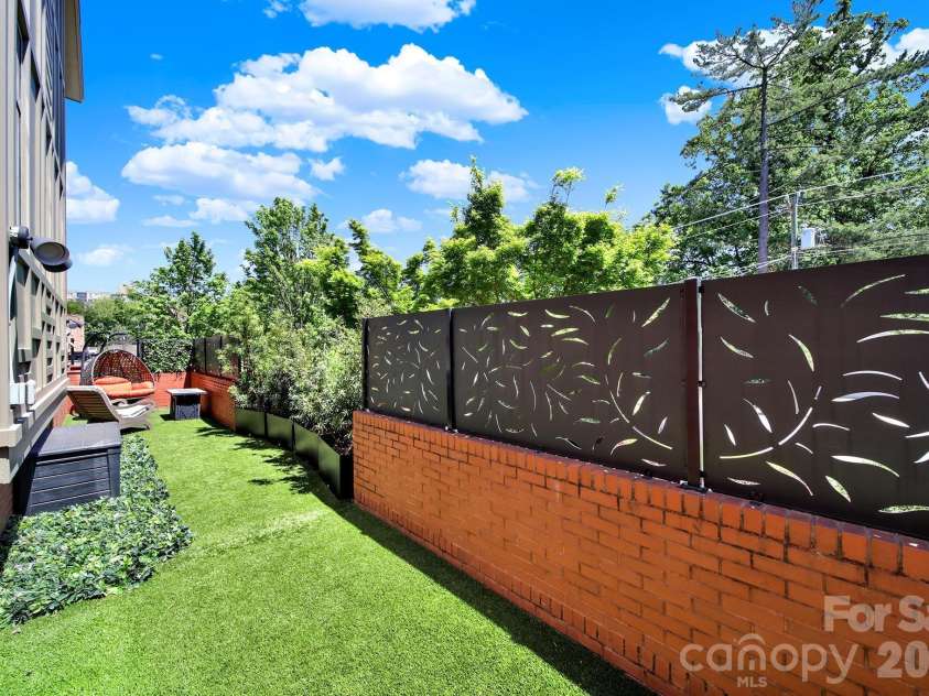 1930 Scott Avenue, Charlotte, NC 28203.  MLS# CAR4367127, YatesRealty ID 29105. Fully fenced, private garden-level brick courtyard with premium astroturf (not a shared space).