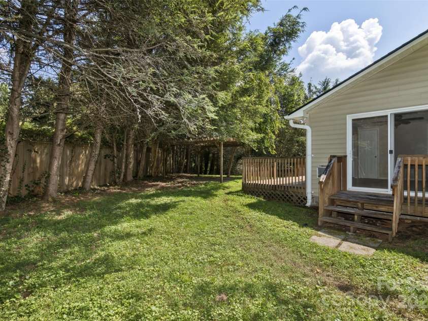 15 Beaverdam Knoll Road, Asheville, NC 28804.  MLS# CAR4283730, YatesRealty ID 29131. The back yard is fenced and features a pergola over a stone patio.