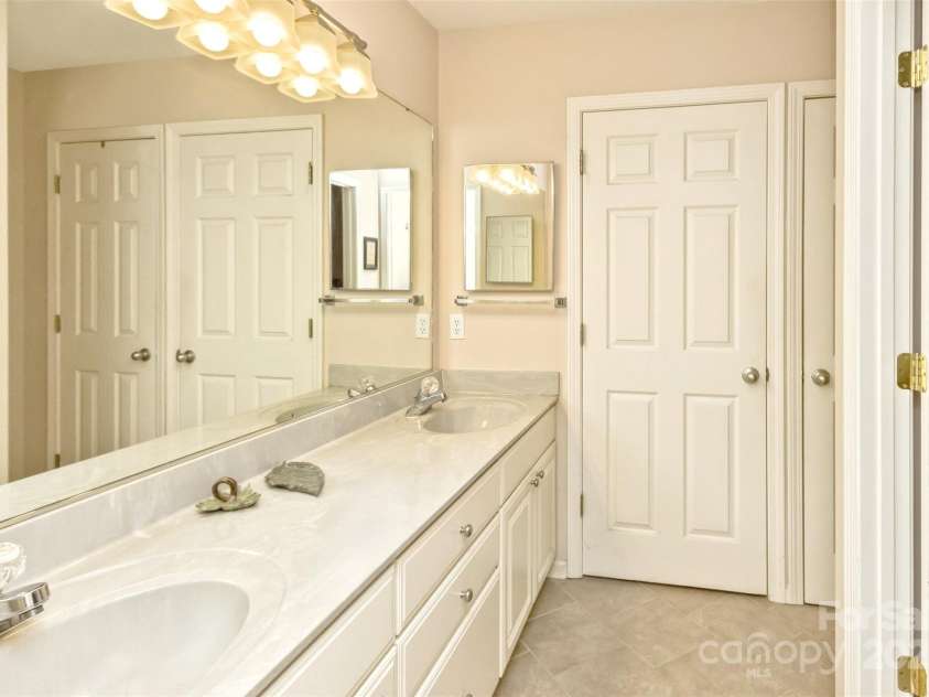 15 Beaverdam Knoll Road, Asheville, NC 28804.  MLS# CAR4283730, YatesRealty ID 29131. The bathroom features double sinks, each with its own medicine cabinet, and two large linen closets.