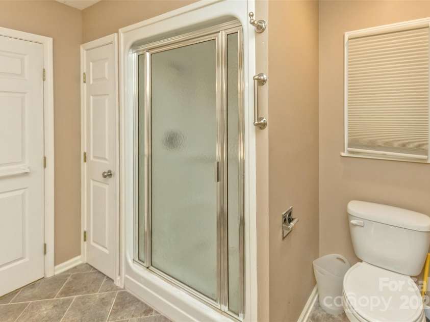 15 Beaverdam Knoll Road, Asheville, NC 28804.  MLS# CAR4283730, YatesRealty ID 29131. The toilet room with a glass-enclosed shower/tub has a separate door for additional privacy.