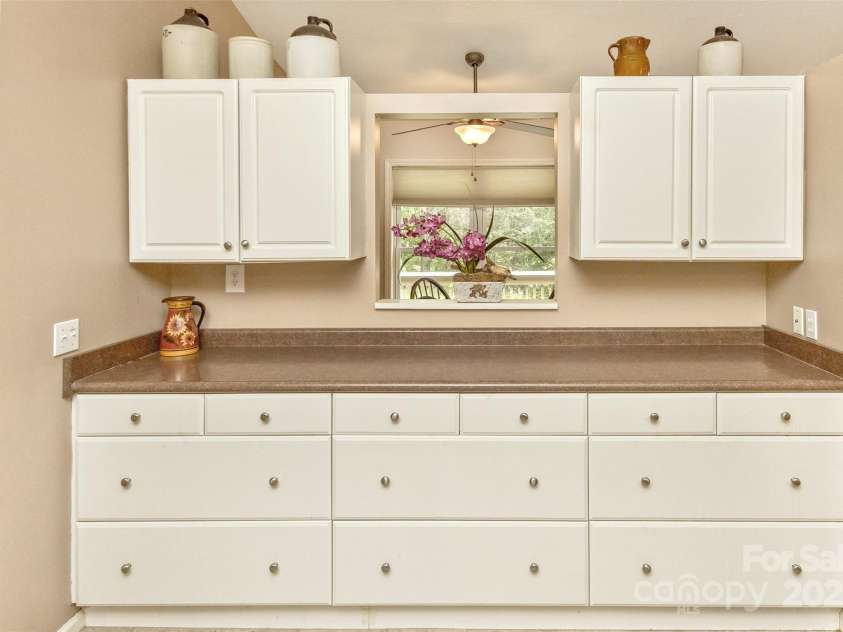 15 Beaverdam Knoll Road, Asheville, NC 28804.  MLS# CAR4283730, YatesRealty ID 29131. Well-designed cabinetry provides an abundance of storage space in the kitchen. The pass-through to the breakfast nook is a great feature as well.