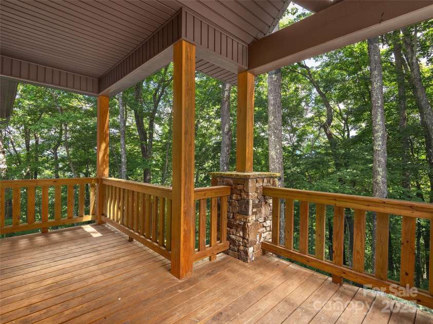 1070 Gold City Lane, Franklin, NC 28734.  MLS# CAR4282550, YatesRealty ID 29132. A welcoming covered porch with wood and stone details—offering privacy and a peaceful treetop view from the moment you arrive.