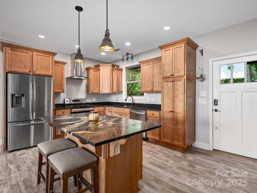 1070 Gold City Lane, Franklin, NC 28734.  MLS# CAR4282550, YatesRealty ID 29132. This stylish kitchen features warm wood cabinetry, eye-catching countertops, and a center island perfect for prep or gathering—designed for both everyday living and entertaining.