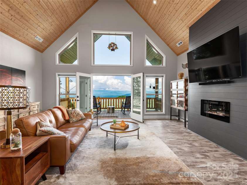 1070 Gold City Lane, Franklin, NC 28734.  MLS# CAR4282550, YatesRealty ID 29132. Vaulted ceilings, cozy fireplace, and mountain views for days—this living room is made to impress and unwind.