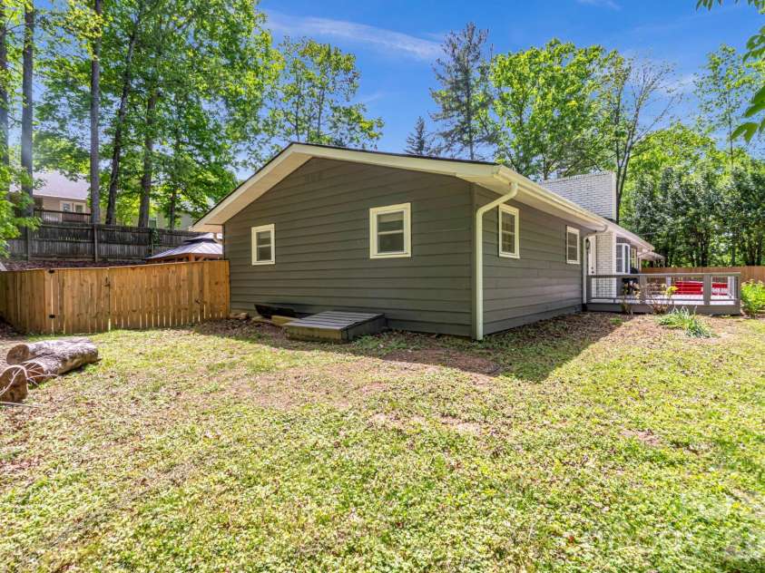 35 Timberview Drive, Arden, NC 28704.  MLS# CAR4373385, YatesRealty ID 29135. Side view with easy crawlspace access and a secure gate leading to the backyard.