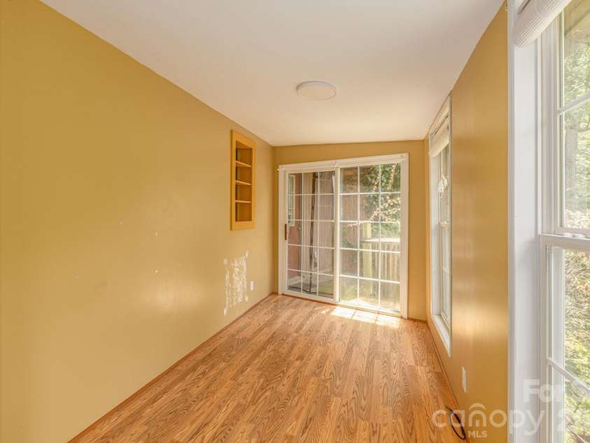 295 Richmond Road, Bakersville, NC 28705.  MLS# CAR4387768, YatesRealty ID 29139. Glass doors in sunroom lead to small deck, with steps into the back yard.
