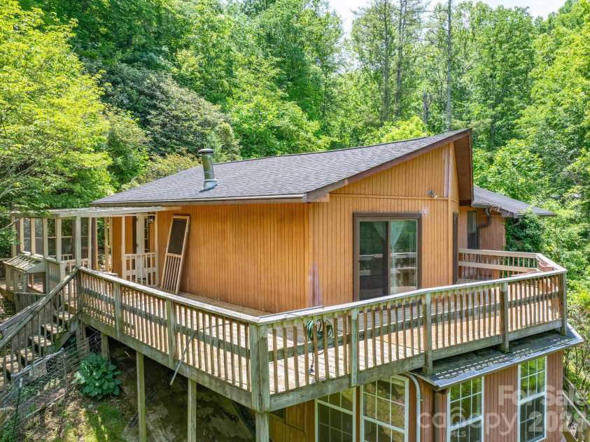 295 Richmond Road, Bakersville, NC 28705.  MLS# CAR4387768, YatesRealty ID 29139. Large wrap around deck. Covered area was screened at one time. 