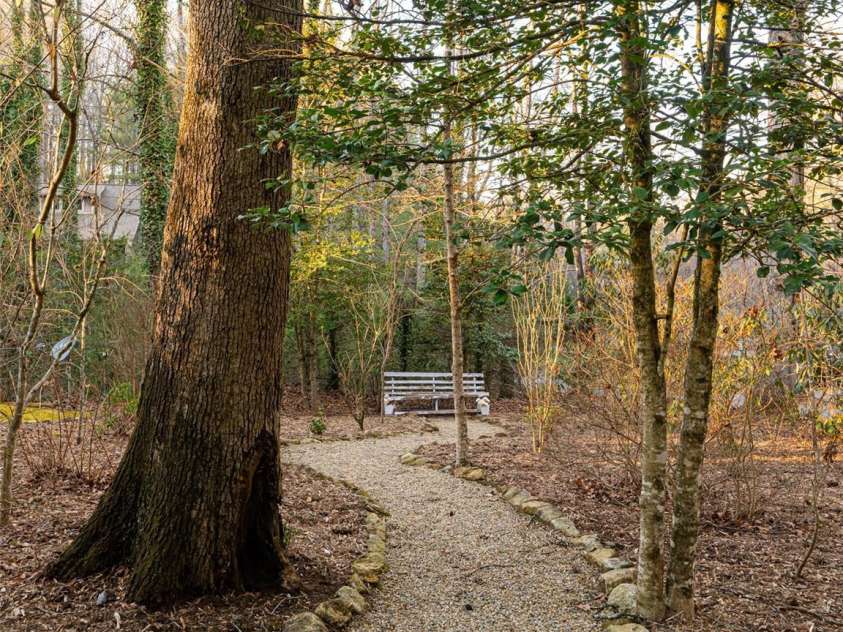 100 Wolf Shoals Drive, Hendersonville, NC 28739.  MLS# CAR4333977, YatesRealty ID 29146. Charming path to a garden bench.