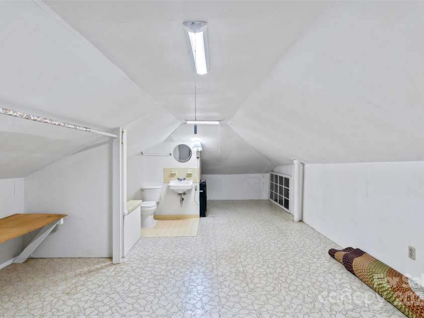 23 & 25 Oteen Park Place, Asheville, NC 28805.  MLS# CAR4287838, YatesRealty ID 29157. The full bathroom in the attic space above unit 25 has low ceiling height which is functional but not counted in the square footage. It also has a wall heater and lots of additional storage space.