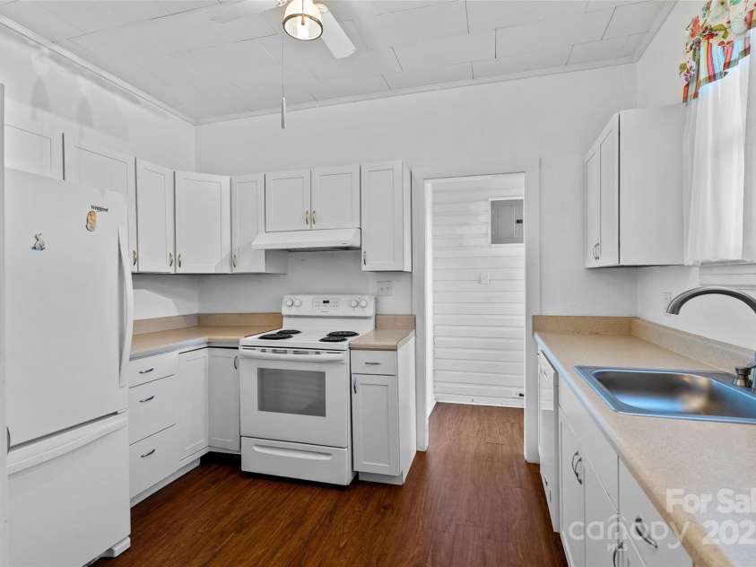 23 & 25 Oteen Park Place, Asheville, NC 28805.  MLS# CAR4287838, YatesRealty ID 29157. The kitchen is well-equipped with modern, bright white cabinets. There is a place for everything and ample counter space to work on. I like that the kitchen also leads to the laundry room, which has an exterior en