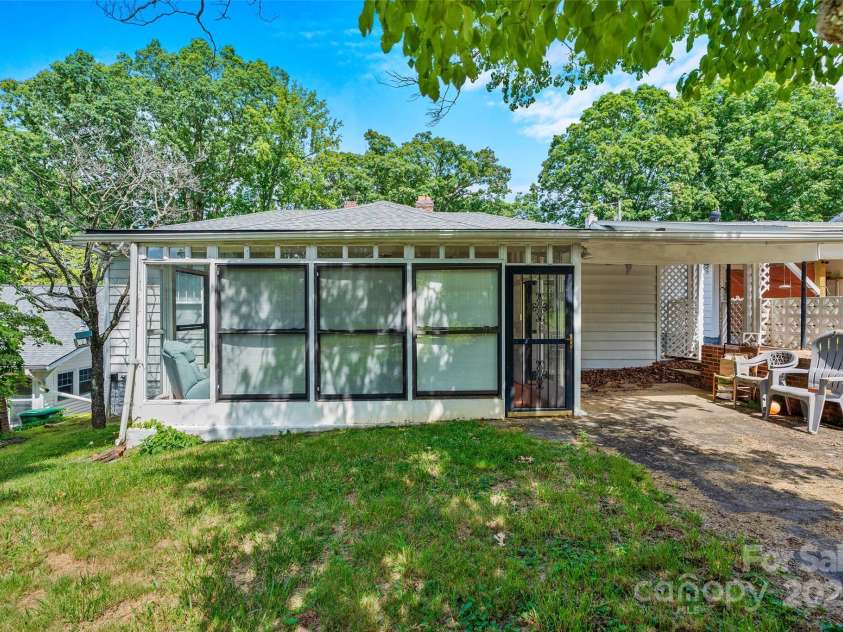 23 & 25 Oteen Park Place, Asheville, NC 28805.  MLS# CAR4287838, YatesRealty ID 29157. The sunroom is a spacious place, with both units 23 and unit 25 and the backyard having doors to access it.