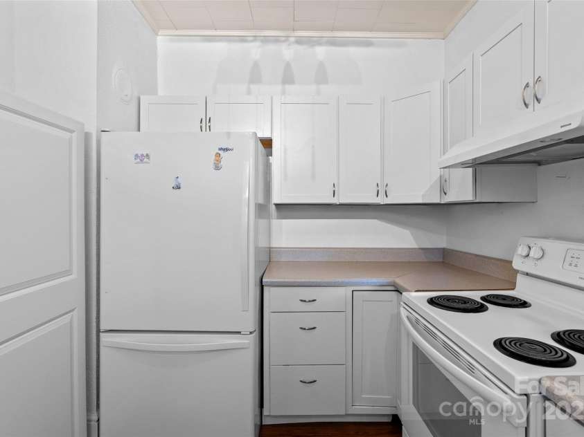 23 & 25 Oteen Park Place, Asheville, NC 28805.  MLS# CAR4287838, YatesRealty ID 29157. View of the kitchen showing the fridge and more storage located just to the left of the fridge.