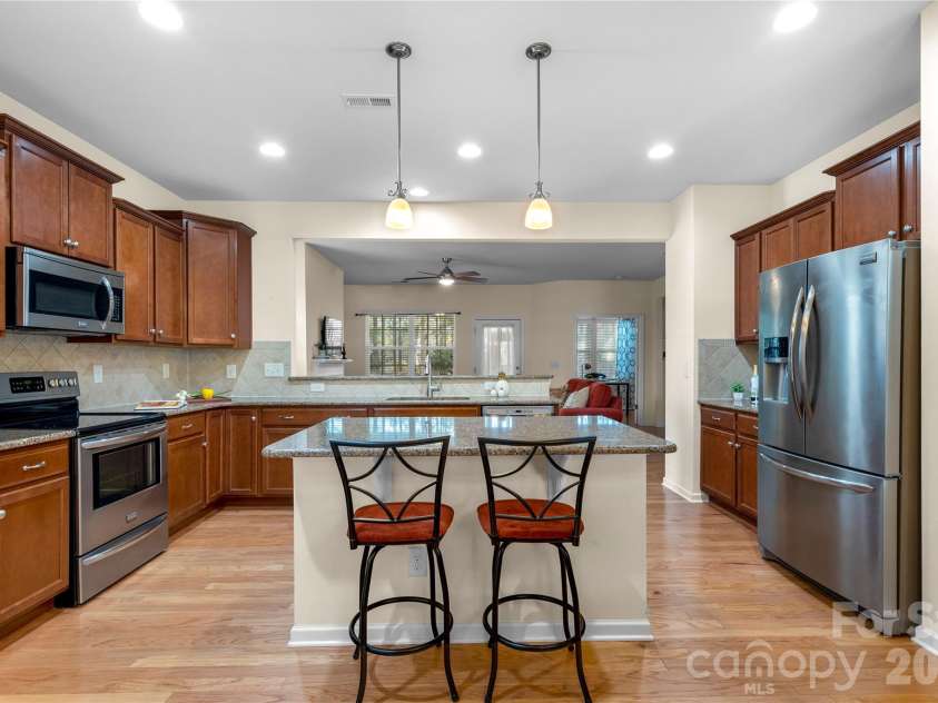 1016 Wells Lane, Fort Mill, SC 29707.  MLS# CAR4359886, YatesRealty ID 29188. View from formal dining room looking into Chief s Kitchen into adjoining Great room ! Gleaming Hardwoods through out most of the main floor!