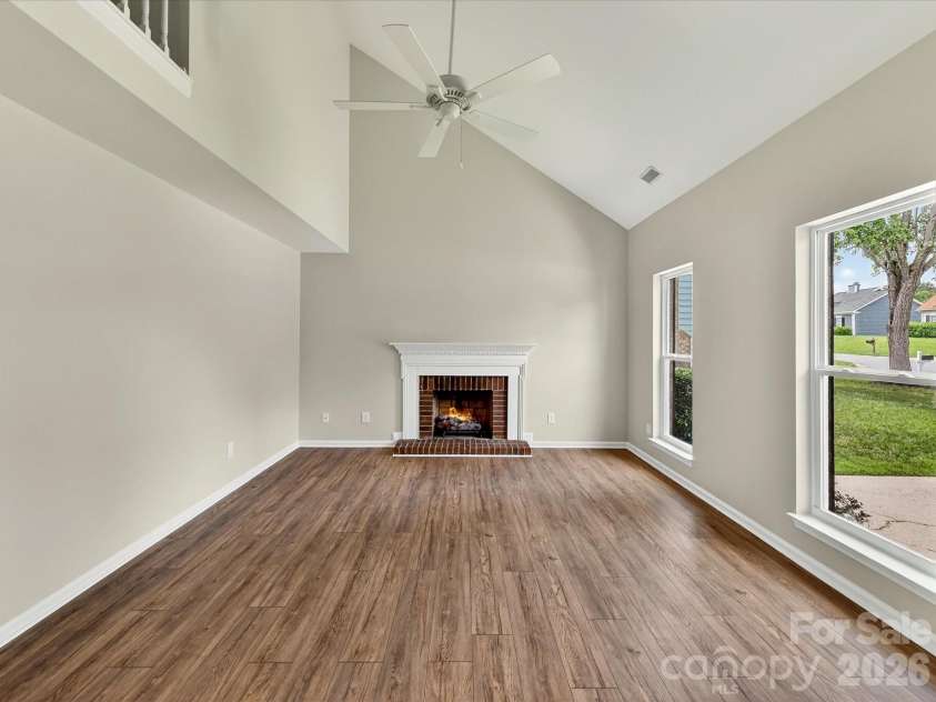 9716 Pernell Lane, Charlotte, NC 28213.  MLS# CAR4383771, YatesRealty ID 29190. Dramatic two-story great room features soaring vaulted ceilings, abundant natural light, updated flooring, and a cozy fireplace creating the perfect open and inviting gathering space.