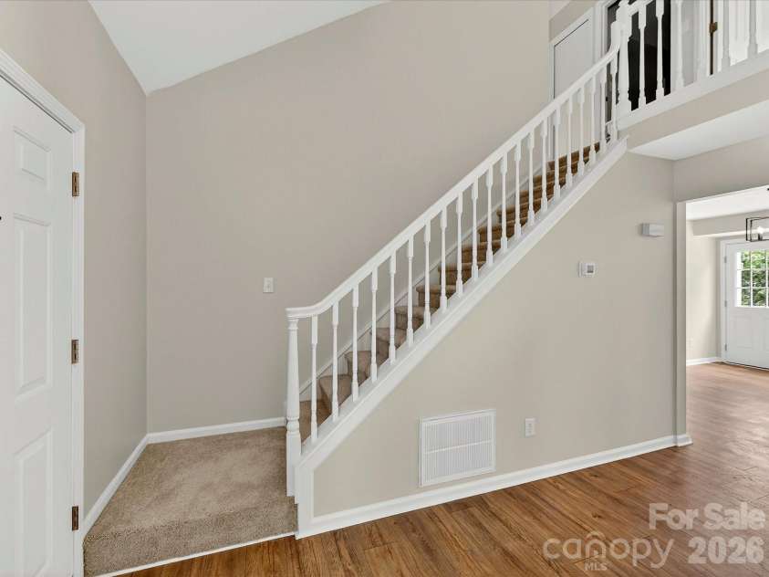 9716 Pernell Lane, Charlotte, NC 28213.  MLS# CAR4383771, YatesRealty ID 29190. Elegant staircase with classic white balusters overlooks the open-concept living space, adding architectural charm and an airy feel to the home.