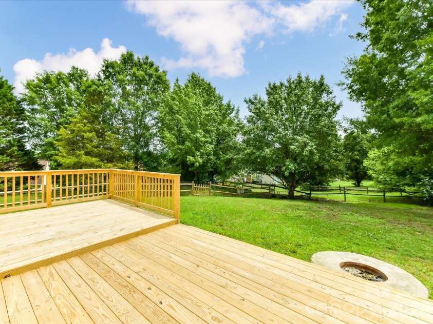 9716 Pernell Lane, Charlotte, NC 28213.  MLS# CAR4383771, YatesRealty ID 29190. Expansive backyard retreat features a spacious new deck and built-in firepit area, perfect for outdoor entertaining, relaxing, and enjoying peaceful tree-lined views.